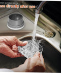 Hands rinsing the Premium Portable Electric Citrus Juicer's detachable cup under running water in a sink.