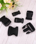 2 Pack 1-1/2 Inch Side Release Buckles in black displayed on wood surface with floral decoration, suitable for backpacks and luggage.