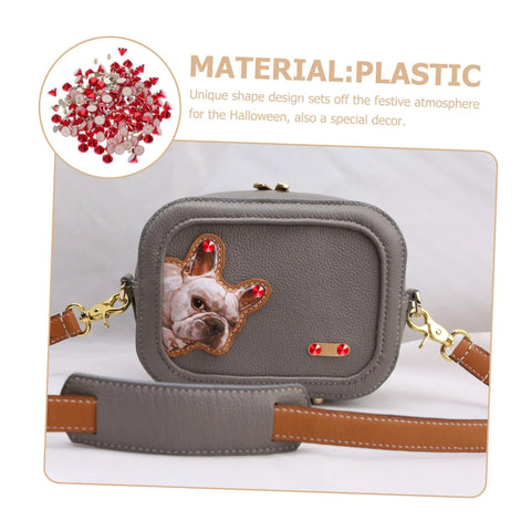 Gray faux-leather crossbody bag with a dog-face patch and red rhinestones, gold hardware.