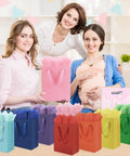 4 Pack Gift Bags With Handles 8 X 5 X 10 Inch Includes 8 Tissue Paper Color Combo Pink Purple Deep Blue Sky Blue Perfect For Birthday Parties Baby Showers Weddings Mothers Day Fathers Day Favors displayed in front of smiling women at a baby shower