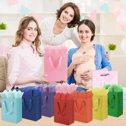 4 Pack Gift Bags With Handles 8 X 5 X 10 Inch Includes 8 Tissue Paper Color Combo Pink Purple Deep Blue Sky Blue Perfect For Birthday Parties Baby Showers Weddings Mothers Day Fathers Day Favors displayed in front of smiling women at a baby shower