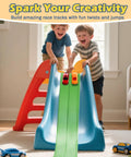 Two children playing with Awesome Flexible Race Track For Kids 3 Plus 15 Foot Roll Up Car Track on a slide indoors
