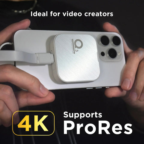 Person holding an iPhone 15 Pro Max with a Magnetic External SSD 1TB For On The Go Storage With MagSafe Portable USB 3.2 Gen 2x2 Drive.