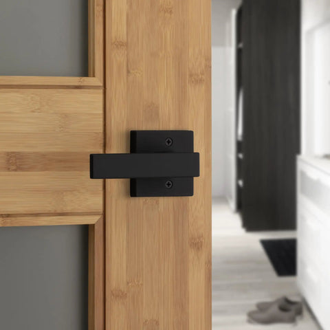 Matte black interior privacy door lever with lock installed on wooden door for bedroom and bathroom with Microban protection.