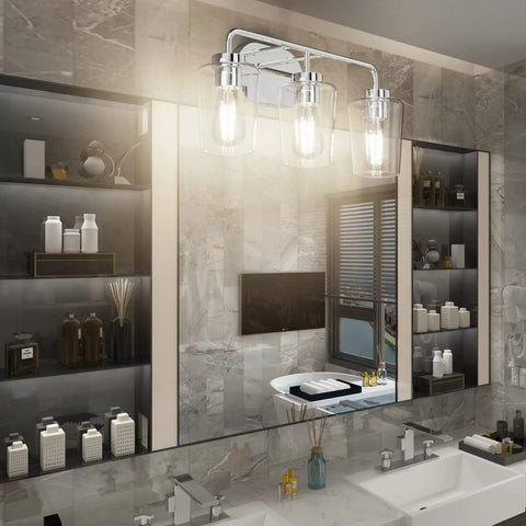 Three Light Industrial Style Bathroom Vanity Fixture In Stainless Steel Chrome Finish With Clear Glass Shades For Farmhouse Bath Lighting And Easy Wall Mount Installation mounted above a modern double sink bathroom.