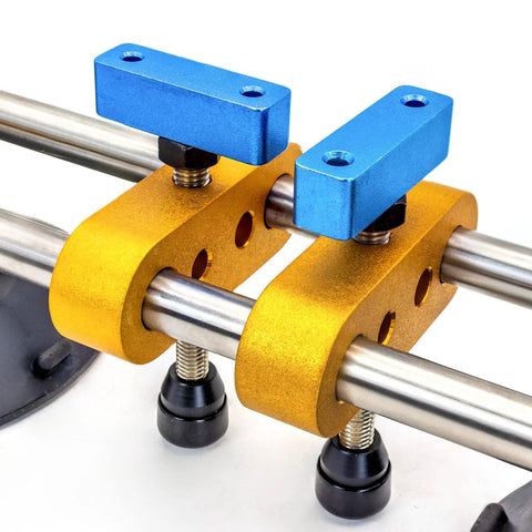 Stone seam setter tool with two blue vacuum suction blocks mounted on yellow clamps around a chrome rod.