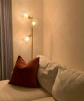 Industrial Floor Lamp With Reading Light, 65-inch tall golden standing lamp with three cage lampshades beside a sofa