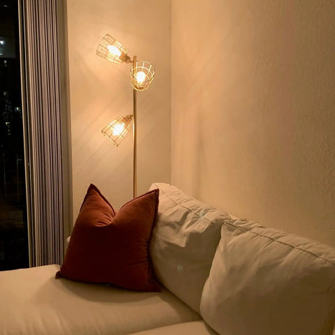 Industrial Floor Lamp With Reading Light, 65-inch tall golden standing lamp with three cage lampshades beside a sofa