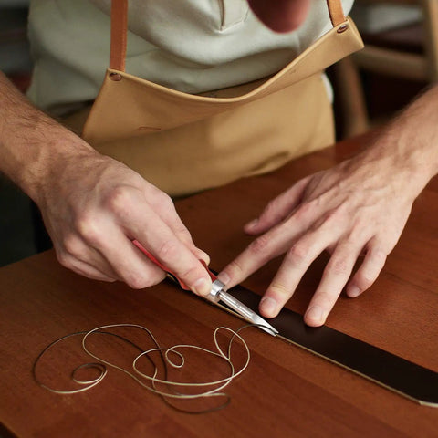Person using Leather Craft Tool Set Six Piece With Four Edge Bevelers In 0.8mm, 1.0mm, 1.2mm, 1.5mm, Plus Cutting Knife on leather strip.