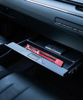 GODESON dual-head pencil tire gauge, black body in red packaging, inside car glove compartment.