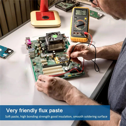 Person applying No Clean Rosin Solder Flux Paste For Electronics on circuit board, 100g pack of 2, with multimeter nearby.