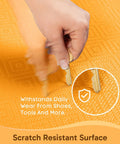 Bright orange anti fatigue kitchen mat being scratched by keys to show scratch resistance features.