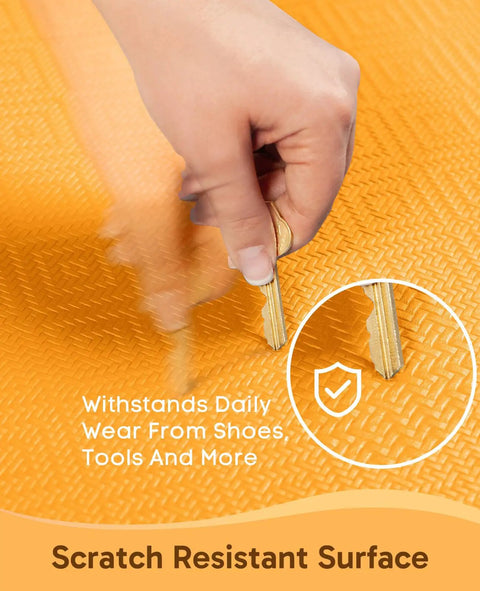 Bright orange anti fatigue kitchen mat being scratched by keys to show scratch resistance features.