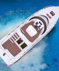 Top view of 2.4G Remote Control High Speed RC Yacht with 20 Kmph Top Speed on water, showcasing deck and control panel.