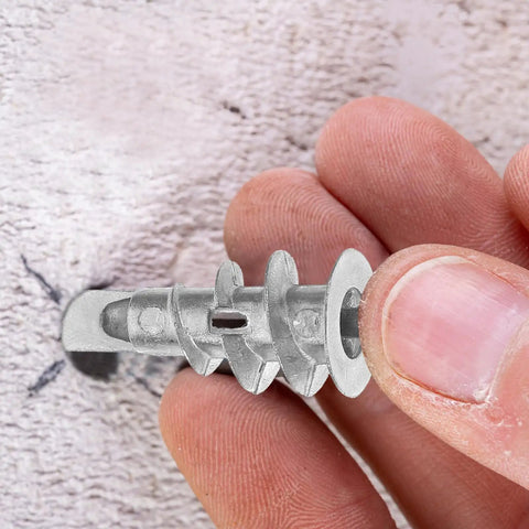 Heavy Duty Self Drilling Drywall Anchor Kit with zinc alloy anchor in hand against wall for secure fixes.