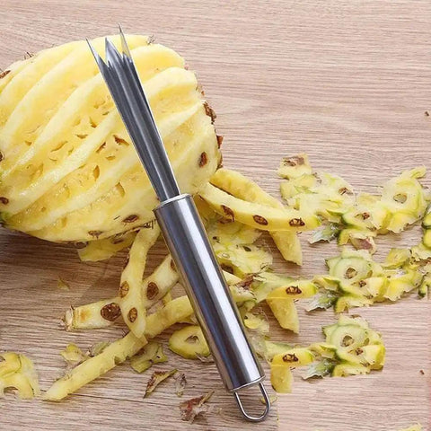 Pineapple Eye Remover And Core Cutter Tool V Shaped Stainless Steel Kitchen Gadget next to a partially peeled pineapple