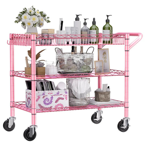Rock Solid Heavy Duty Pink Metal Rolling Cart With Three Roomy Shelves And Smooth Rolling Wheels filled with beauty products and decor.