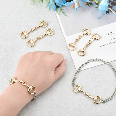 Six Piece Set Medium Horse Bit Buckles D Ring Gold Snaffle Buckles on bracelet and loose on table