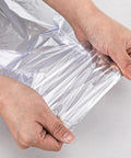 Hands stretching clear POF film from Bulk 500 Pack Heat Shrink Wrap Bags For Packaging, showcasing material flexibility.