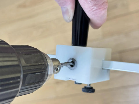Close-up of Pro Grade Window Screen Pin Plunger Jig Tool in use, drilling a hole into a screen frame for DIY repairs.