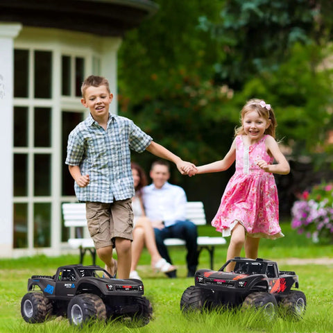 Kids playing with Dope Amphibious RC Monster Truck For Kids With Dual Batteries near a garden, two trucks in foreground.
