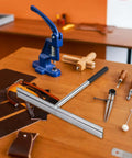 15.25 Inch Sheet Metal Folding Hemming Tool with Heavy Duty Steel Construction on workshop table surrounded by leather tools