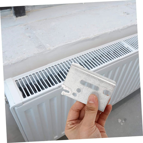 Hand holding steel bracket near radiator for Heavy Duty Track Jamb Bracket For Sliding Doors Steel Construction With Easy Install Built Tough Durable Hardware For Reliable Support And Smooth Operation For Long Lasting Use.
