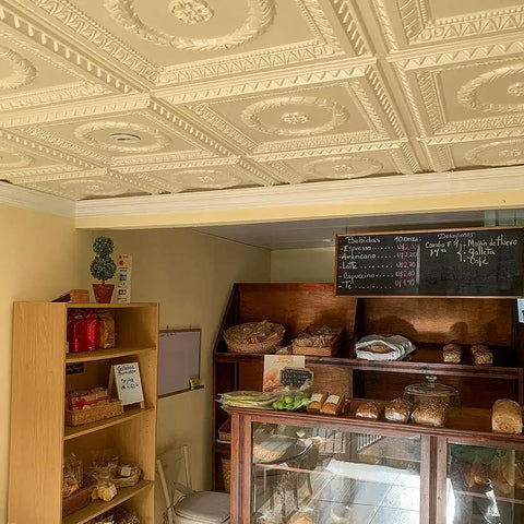 Laurel Wreath Faux Tin Ceiling Tiles White Pearl 25 Pack installed in a bakery, showing a classic tin look ceiling design.