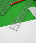 Dead Simple Acrylic Quilting Rulers And Nifty Fabric Cutting Templates For Patchwork Projects on green fabric with a red pencil.
