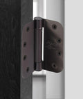 Heavy Duty 4 Inch Self Closing Spring Door Hinges Two Pack With Adjustable Closing Power And Oil Rubbed Bronze Finish installed on wooden door.