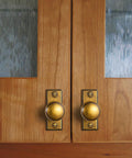 Six Pack Dope Antique Brass Cabinet Knobs With Backplates on wooden cupboard doors