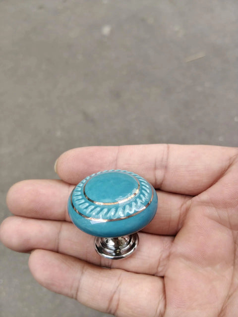 Totally Groovy Blue Mushroom Ceramic Cabinet Knobs, 6 Pack of Glossy Round Drawer Pulls for Dresser and Wardrobe, 1.38 Inch Diameter, Smooth Polish, 3 Screw Sizes Included held in hand.