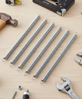 Six Pack Heavy Duty Screen Door Springs Three Eighths Inch By Six And A Half Inch Zero Point Zero Four Seven Inch Thick Dual Hook Tension Springs displayed on a wooden workbench with tools.