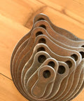 Stack of Half Inch AR500 KYL Gong Target Set 1 In To 8 In Eight Pack For Progressive Accuracy Training on wooden surface