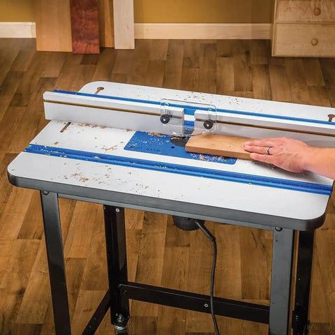 High Pressure Laminate Router Table Top With 10 Point Plate Leveling For Precision Cuts Smooth Low Friction Routing Surface MDF Core Woodworking Table Top Pro Fence Compatible With Adapter Kit Sold Separately, showing a hand guiding a wooden board along the fence for precise cutting.