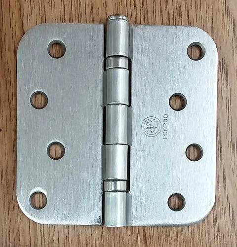 Smooth Satin Nickel Ball Bearing Door Hinges, 4 Inch With 5 Eighth Radius, shown on wooden surface