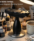 Large Magnetic Base Miniature Painting Handle With Stable Clamp For 50mm To 140mm Bases, shown on a cluttered workbench.