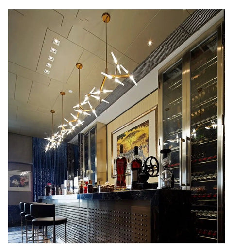 Modern Herringbone Pendant Lights Dimmable G9 Hanging Fixture over a bar with a stylish, contemporary decor, providing ambient lighting.