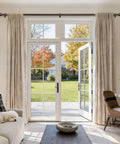 Living room patio with Beefy Bronze Curtain Rod 1 Inch Adjustable Drapery Rod From 32 To 86 Inches For Living Room Bedroom Indoor Outdoor Use With Rust Resistant Finish And Smooth Glide, framing beige curtains and garden view.