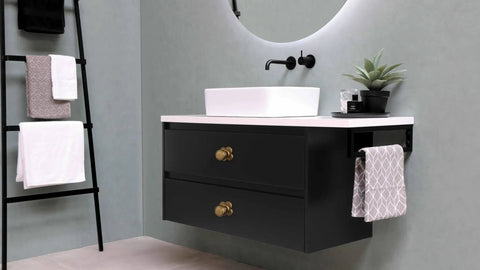 Top Shelf Antique Brass Cabinet Knobs With Quatrefoil Backplate on modern black bathroom vanity with white countertop.