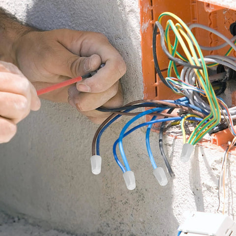 Close-up of high-temperature ceramic wire connectors on blue wires with white porcelain caps in an electrical box