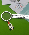 Funny Aerospace Engineer Keychain Gift For Graduation And Appreciation with rocket charm on green background