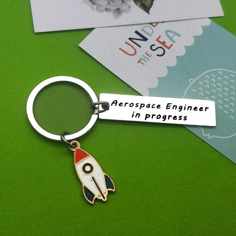 Funny Aerospace Engineer Keychain Gift For Graduation And Appreciation with rocket charm on green background