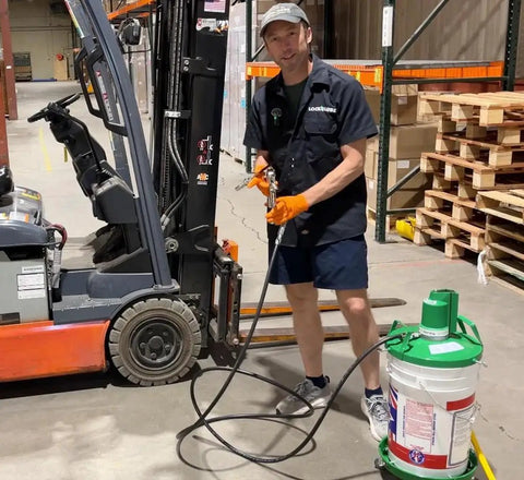 Person demonstrating Beefed Up Air Powered Grease Pump Kit With Booster Gun, Z Swivel And Coupler For 5 Gal Pails, 10000 PSI