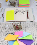 Colorful 4x6 Inch Sticky Notes, Eight Bright Colors, 320 Sheets Total Across Eight Pads, Mega Sticky Adhesive next to a notebook.