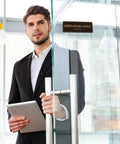 Man holding tablet by glass door with Employees Only Sign For Doors And Walls Two Pack Self Adhering Staff Only Sign 9 By 3 Inches