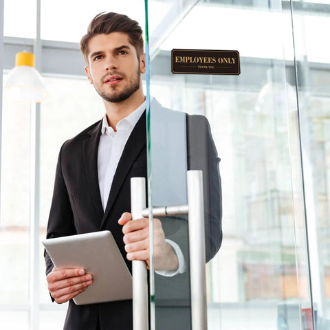 Man holding tablet by glass door with Employees Only Sign For Doors And Walls Two Pack Self Adhering Staff Only Sign 9 By 3 Inches