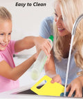 Higoney 17-piece kids kitchen set, plastic utensils with yellow cutting board, front view at sink being rinsed.