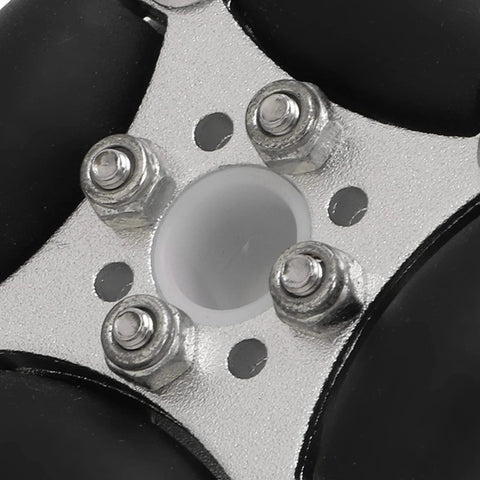 Close-up of compact double aluminum omni wheel hub with four bolts and white center insert on metal plate.