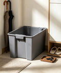 Medium Open Top Stackable Plastic Storage Bin With Reinforced Carry Handles Heavy Duty Gray Utility Tote in corner by umbrellas.